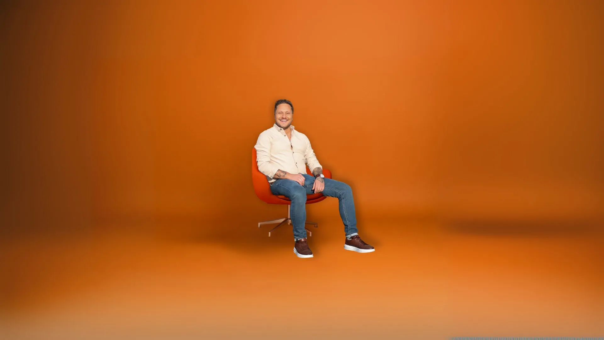 Patryk Olszewski w pomarańczowej scenerii studyjnej