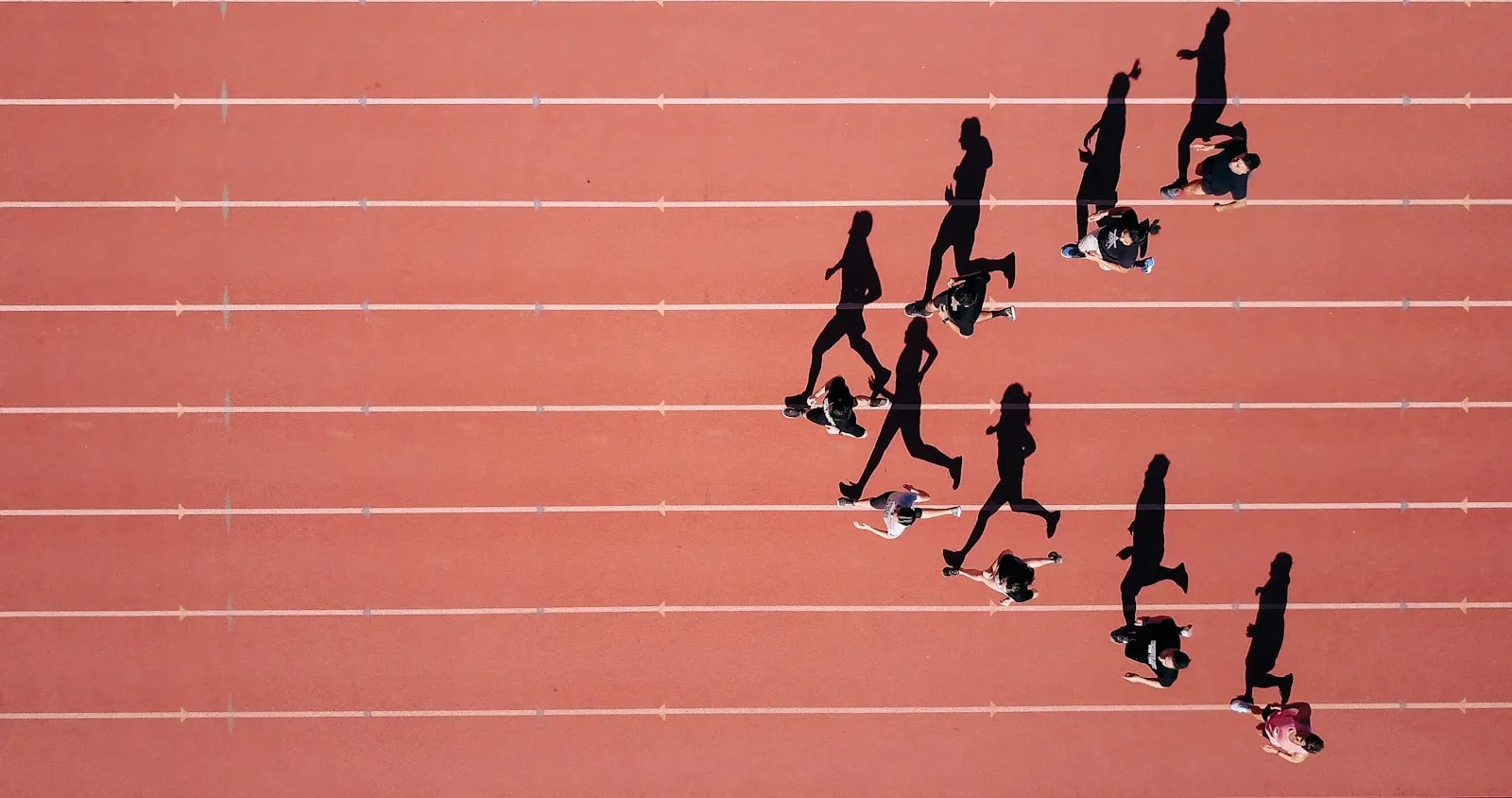 Biegacze na bieżni lekkoatletycznej widziani z lotu ptaka